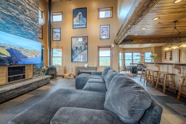 living room featuring tile patterned floors, wooden ceiling, and a high ceiling