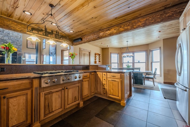 kitchen with appliances with stainless steel finishes, wooden ceiling, pendant lighting, and dark tile patterned floors