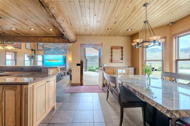 dining space with a chandelier, light tile patterned floors, and wood ceiling