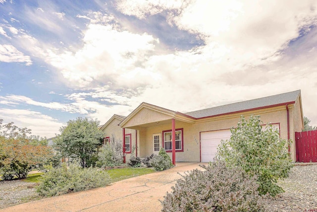 single story home with concrete driveway, an attached garage, and stucco siding