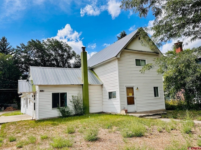 rear view of house featuring a garage and a lawn