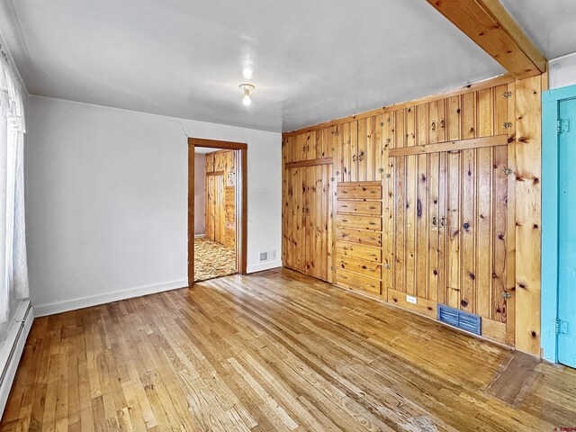 carpeted spare room with a wall mounted AC and a baseboard radiator