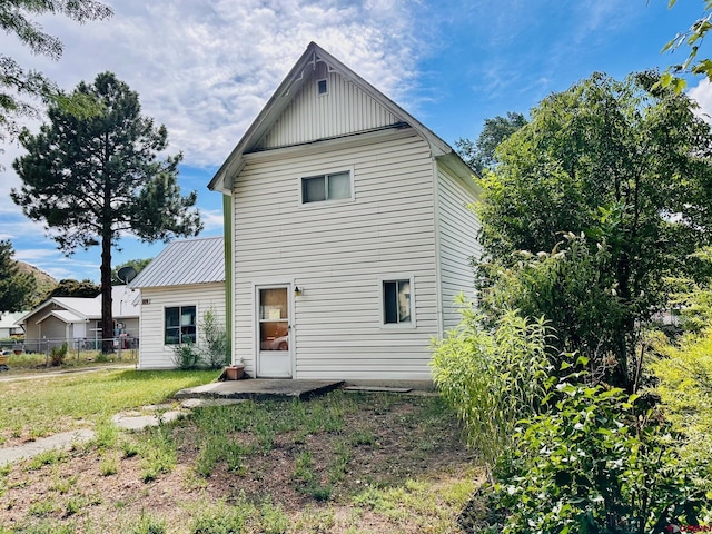 back of house with a lawn