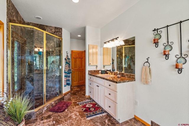 bathroom featuring vanity, a shower stall, and baseboards