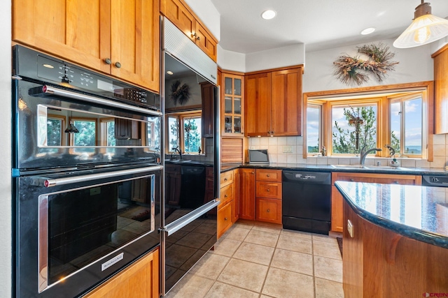 kitchen with a sink, backsplash, double oven, brown cabinetry, and dishwasher