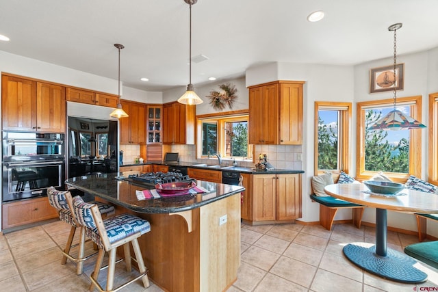 kitchen with multiple ovens, cooktop, tasteful backsplash, and a wealth of natural light