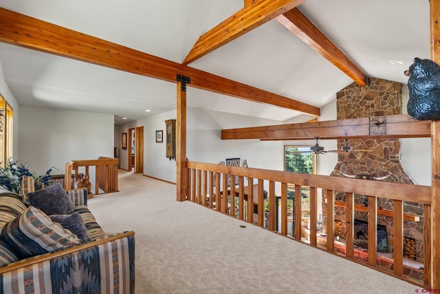 interior space with an upstairs landing, vaulted ceiling with beams, and carpet floors