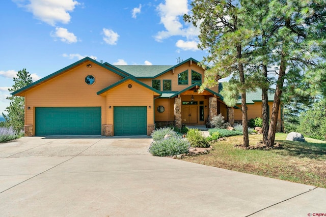 view of front of house featuring concrete driveway, an attached garage, and stone siding