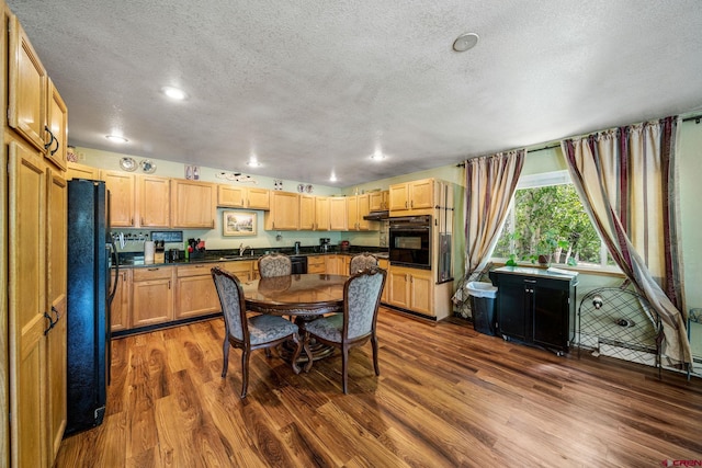 dining space with a textured ceiling, sink, and wood-type flooring