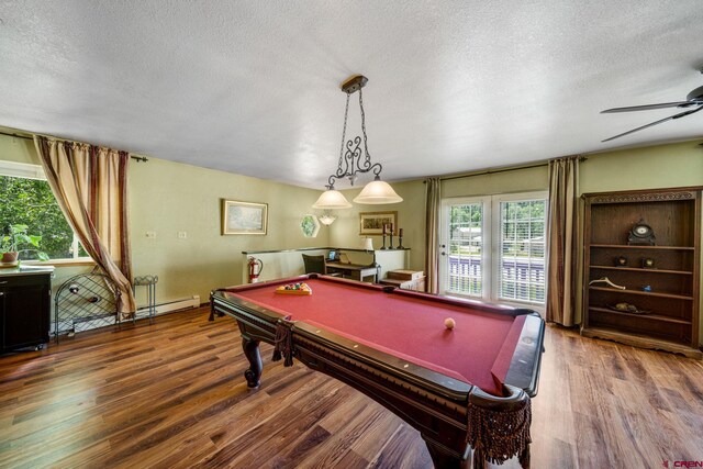 playroom featuring a textured ceiling, wood-type flooring, pool table, and a baseboard radiator