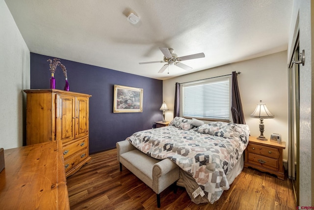 bedroom featuring ceiling fan, dark hardwood / wood-style flooring, and a textured ceiling