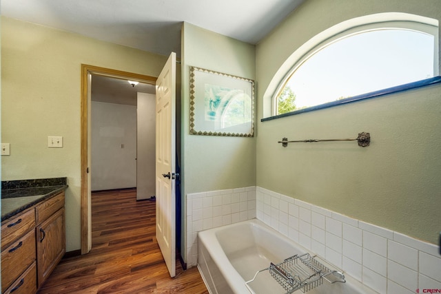 bathroom featuring a tub, wood-type flooring, and vanity