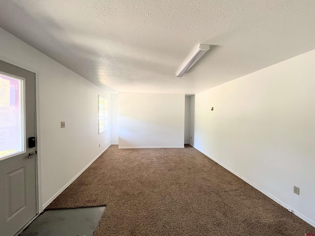 carpeted spare room with a textured ceiling