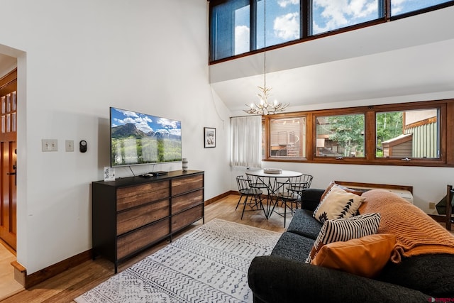 living room featuring hardwood / wood-style flooring, an inviting chandelier, and a high ceiling