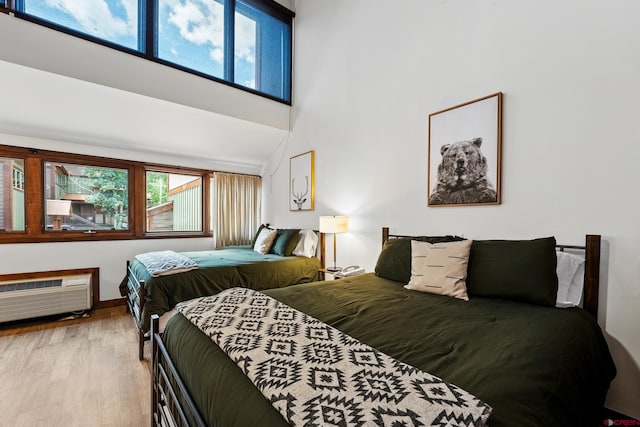 bedroom featuring a high ceiling and hardwood / wood-style flooring