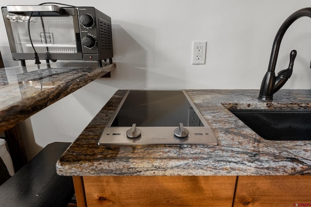 interior details with dark stone counters, stovetop, and sink