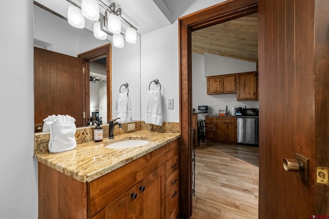 bathroom featuring hardwood / wood-style flooring, vanity, and lofted ceiling