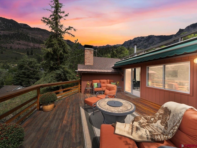 deck at dusk with a mountain view and an outdoor fire pit