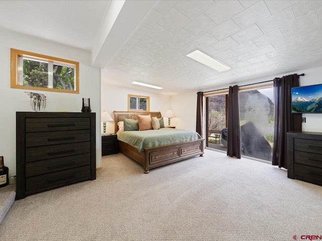 bedroom with access to exterior and light colored carpet