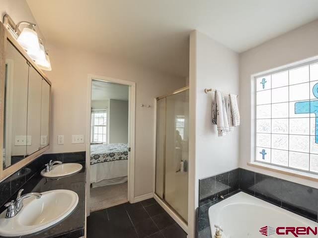 bathroom with plus walk in shower, tile patterned floors, and a healthy amount of sunlight