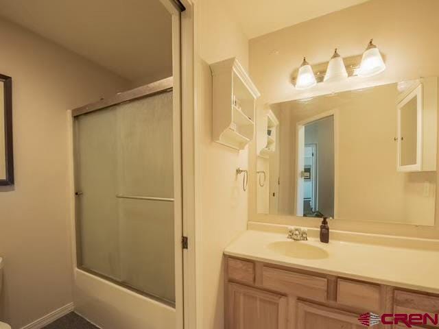 bathroom featuring enclosed tub / shower combo and vanity