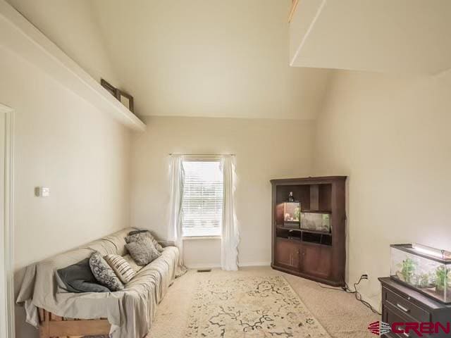 carpeted living room featuring vaulted ceiling