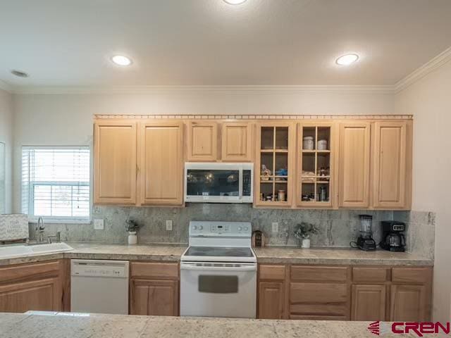 kitchen featuring sink, decorative backsplash, white appliances, and ornamental molding