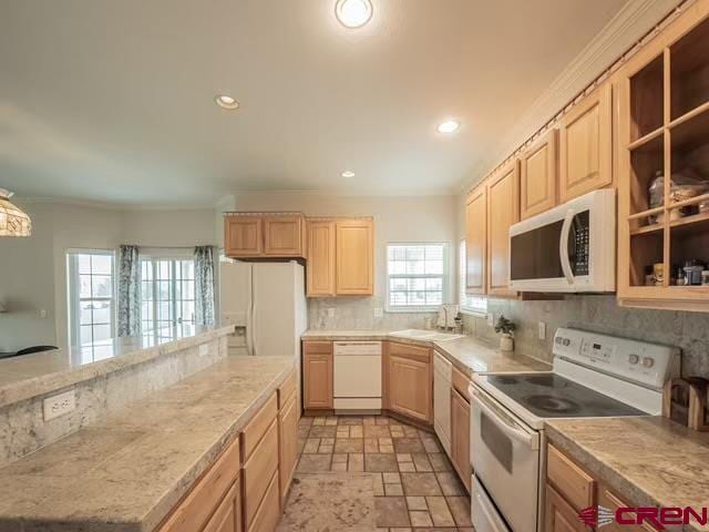 kitchen with backsplash, sink, light brown cabinets, white appliances, and light tile patterned flooring