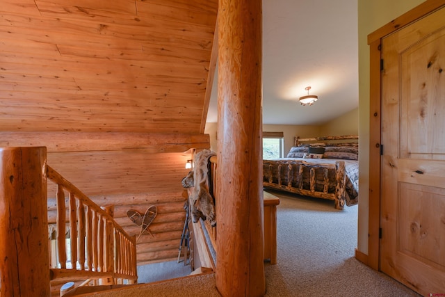 interior space with light carpet, vaulted ceiling, rustic walls, and wood ceiling