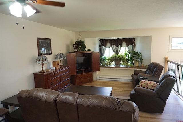 living room featuring light hardwood / wood-style flooring, ceiling fan, and a baseboard heating unit