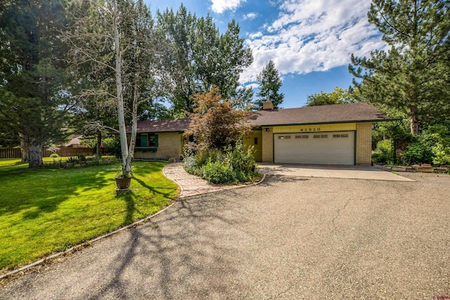 ranch-style home with a front yard and a garage