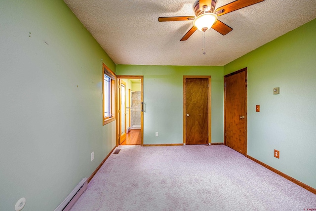 unfurnished bedroom featuring ceiling fan, light colored carpet, a textured ceiling, and ensuite bath