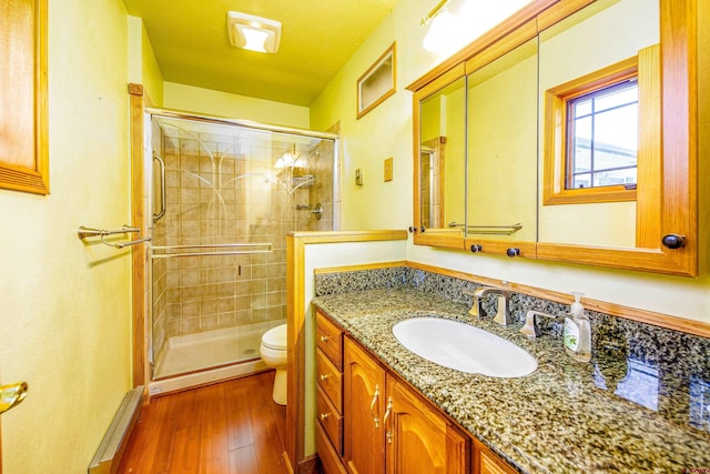 bathroom featuring vanity, hardwood / wood-style flooring, toilet, a textured ceiling, and a shower with shower door