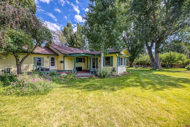 ranch-style house featuring covered porch and a front yard