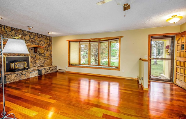 living room with a textured ceiling, hardwood / wood-style flooring, and a healthy amount of sunlight