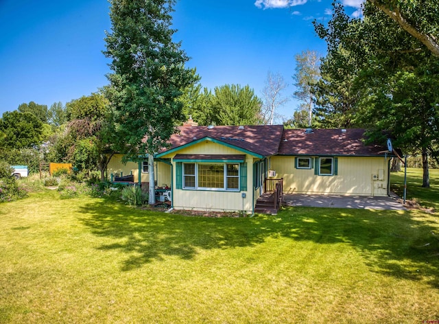 rear view of property with a lawn