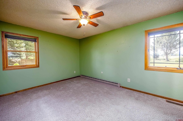 carpeted spare room featuring a textured ceiling, plenty of natural light, ceiling fan, and baseboard heating