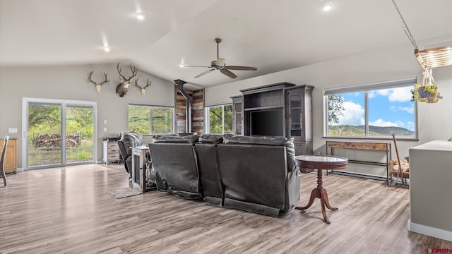 living room with ceiling fan, vaulted ceiling, light hardwood / wood-style flooring, and plenty of natural light