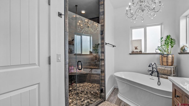 bathroom featuring hardwood / wood-style floors, shower with separate bathtub, vanity, and a chandelier