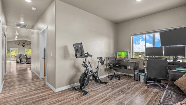 office area featuring vaulted ceiling, hardwood / wood-style flooring, and a healthy amount of sunlight