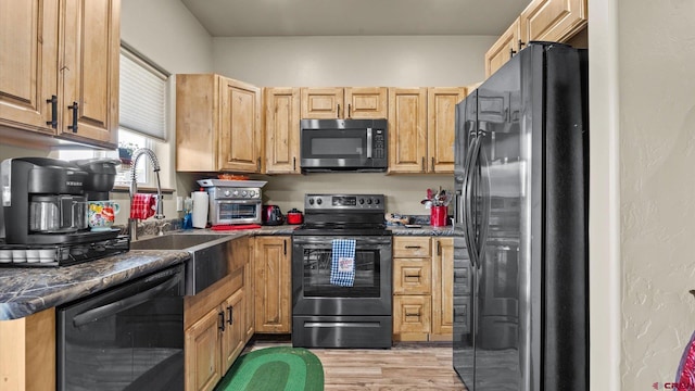 kitchen featuring sink, stainless steel appliances, light brown cabinetry, and light hardwood / wood-style flooring