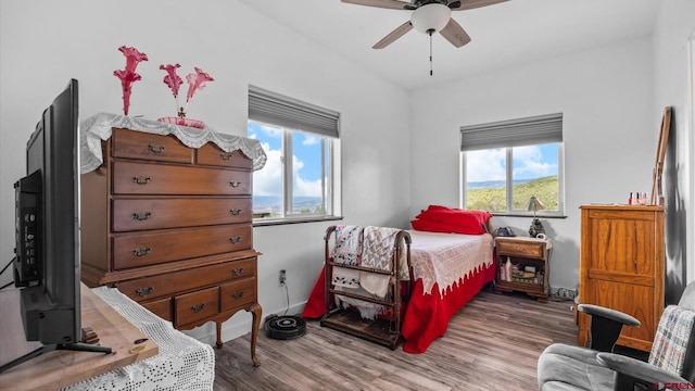 bedroom featuring ceiling fan, multiple windows, and hardwood / wood-style flooring