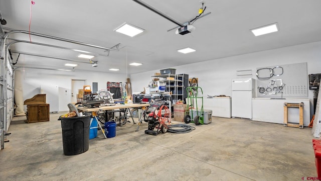 garage featuring a workshop area and white refrigerator