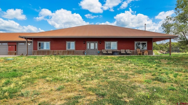 back of property featuring a garage and a yard