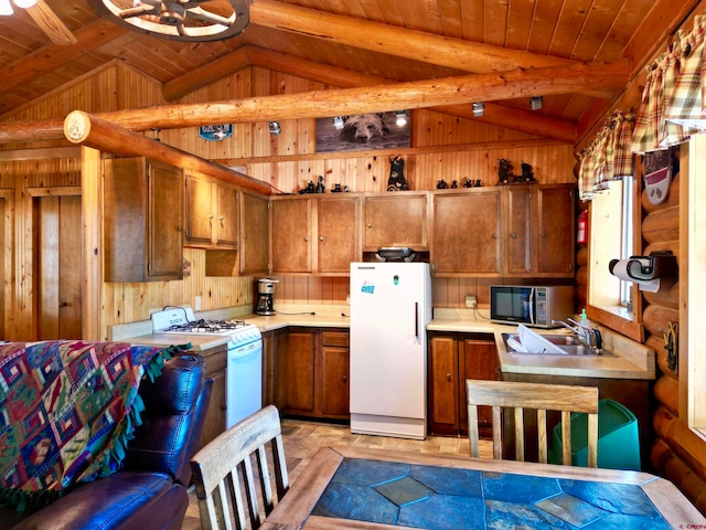 kitchen with wood walls, lofted ceiling with beams, white appliances, and wood ceiling