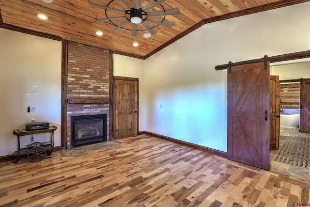 unfurnished living room with light wood-style floors, wooden ceiling, crown molding, and a barn door