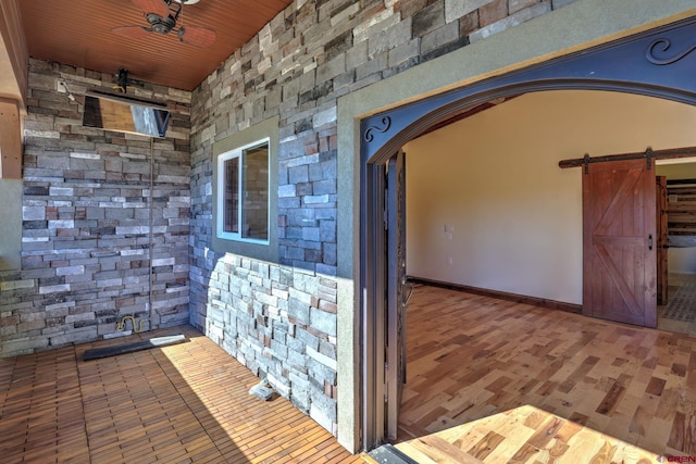 interior space featuring arched walkways, a barn door, and wood finished floors