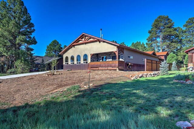 exterior space with a wooden deck and a lawn