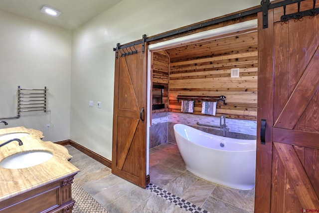 full bathroom with wood walls, a soaking tub, and vanity