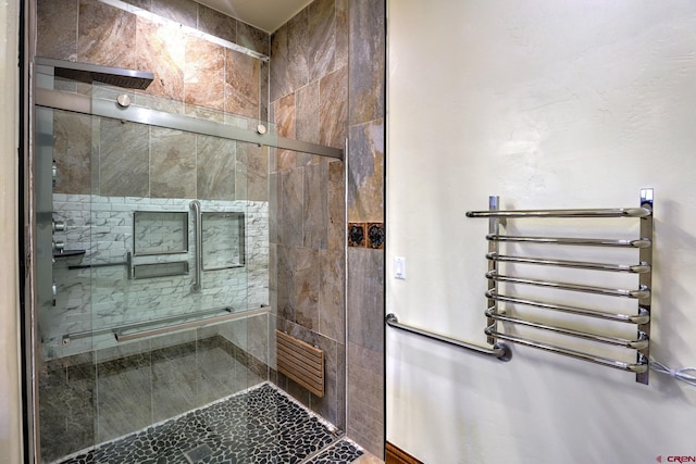 full bathroom featuring tiled shower and radiator heating unit